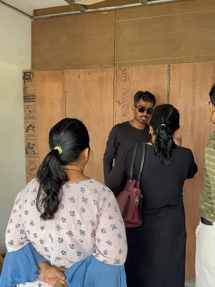 A discussion with clients on-site, right next to the raw plywood structures that will soon become their custom furniture.