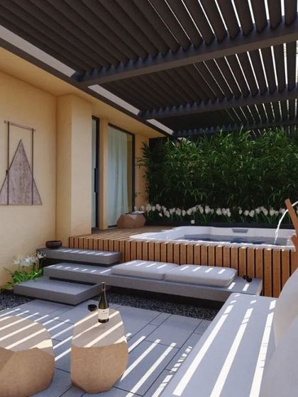 A private garden for a hotel suite, featuring a jacuzzi, multi-level decking, and comfortable seating. This design extends the luxury of the room into a personal outdoor retreat.
