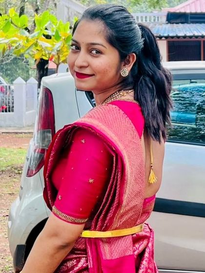 A smiling portrait of the client, showing the simple elegance of her pink ensemble.