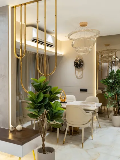 This dining space redefines minimal luxury. Soft beige hues, polished PU finishes, and half-round mouldings bring structure and subtle sophistication. Gold accents and mirror cutouts bounce light, making the space feel open, airy, and effortlessly grand.