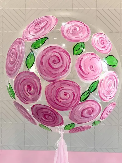 This is a close-up of one of my favorite creations: a hand-painted balloon. I spent hours painting each rose on this clear bubble balloon, turning it into a true work of art. It’s a premium offering for those looking for something exceptionally unique.