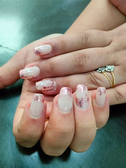 A sheer manicure with a rose gold foil effect, creating a rustic and sparkling texture.