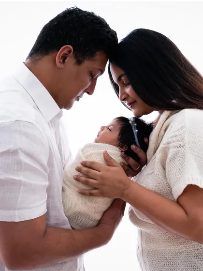 An intimate family portrait, showing the closeness and love between the new parents and their baby.