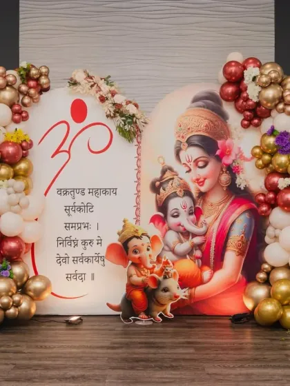 For this special baby shower, we blended tradition with modern decor. The backdrop features a beautiful illustration of Maa Parvati with baby Ganesha, framed by a rich maroon and gold balloon garland to give it a divine and celebratory feel.