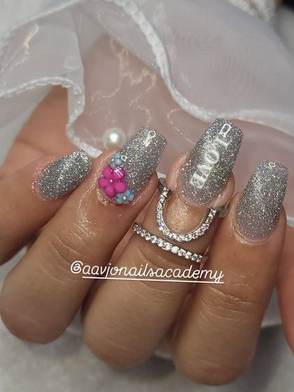 A close-up of the detail work on these engagement nails. The "LOVE" inscription is carefully crafted, and the 3D flowers add texture and dimension to the full glitter look.
