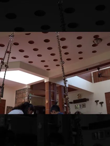 The interior of the Manjunath Residence, featuring a ceiling with inset terracotta pots (part of a filler slab system) and a central swing, blending traditional aesthetics with sustainable building techniques.