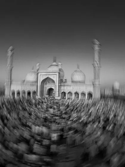 A dizzying, abstract black and white photo of the crowd during Alvida Jumma prayers at Jama Masjid, conveying the overwhelming scale and spiritual fervor of the gathering.