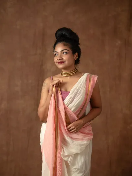 A modern interpretation of a traditional drape, with a high bun and minimalist jewelry for a clean, chic look.