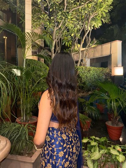 A back shot showing my long, wavy hair against the embroidered blouse of the lehenga.
