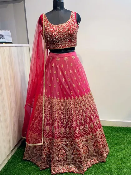 Feel like royalty in this classic Maharani pink lehenga, ideal for a wedding ceremony or grand celebration. The entire set is heavily embroidered with intricate gold threadwork and sequins, creating a rich and luxurious texture.