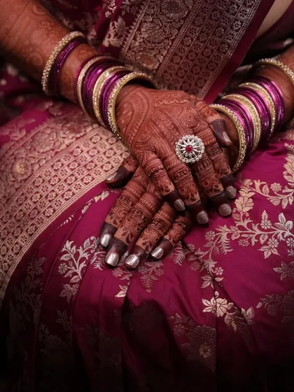A professionally shot photo capturing the elegance of a dark mehendi stain with a bride's engagement attire.