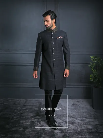 An ash grey Achkan in pure Matka silk, tailored with a clean straight cut and adorned with a jeweled mandarin collar. The textured weave reflects quiet strength and refined luxury.