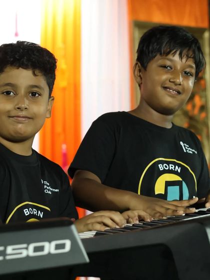 **Piano Duo in Action.** Two of our young pianists share a keyboard during a live performance. Our curriculum encourages collaboration and gives students experience playing with others.