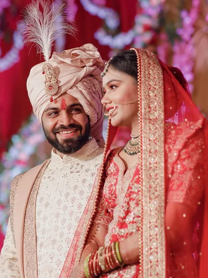 A candid, happy moment between the bride and groom on their wedding stage. Their joyful smiles and loving glance perfectly capture the happiness of their union.