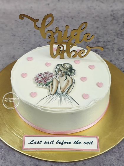 A lovely "Bride to be" cake perfect for a bridal shower. The simple, elegant design features a beautiful illustration of a bride, surrounded by small pink hearts.