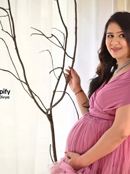 A close-up portrait in the pink ruffled gown. This shot focuses on the mom-to-be's happy expression and the delicate details of the dress.
