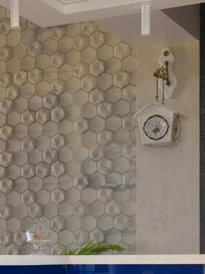 Texture adds depth and character. This image details the 3D hexagonal wall tiles used as a backsplash, creating a unique and visually engaging feature wall in the kitchen.