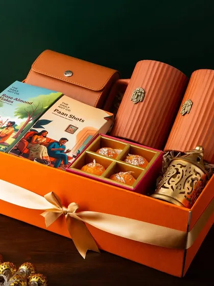 Here’s a look at a vibrant and contemporary festive hamper. I've combined modern Indian snacks like Paan Shots with stylish terracotta-style mugs and a chic leather-finish pouch, all packed in a bright orange box. It’s a gift that’s both trendy and thoughtful.