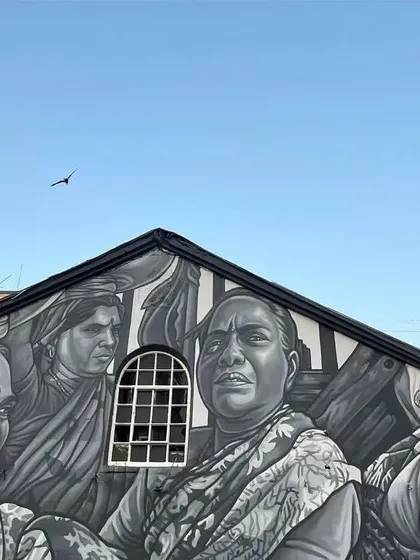 The top of the warehouse at Sassoon Dock, painted in a striking black and white style. This mural showcases the faces of the women who are the backbone of the fishing community.