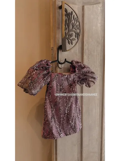A sparkling party top for a little fashionista. This piece is fully embellished with lavender sequins and features dramatic puff sleeves, ready for any celebration.