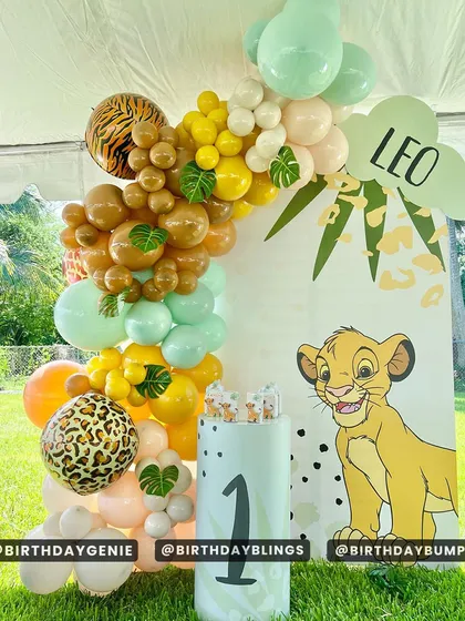 An outdoor Lion King party setup under a tent, showing how I can adapt themes for different venues. The decor features a Simba cutout, a custom-printed plinth, and a vibrant balloon arch.