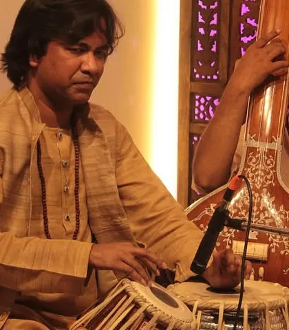 The tabla is the heartbeat of a performance. Here, a skilled percussionist is captured in a moment of intense focus, laying down the rhythmic foundation that breathes life into the melody.
