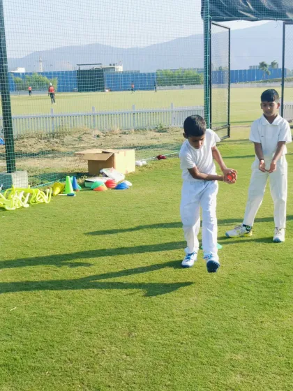 Two young players work together on a catching and throwing drill, building teamwork and communication skills.