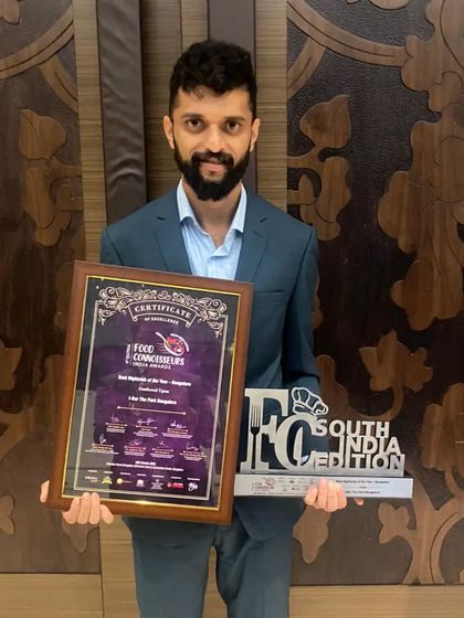A team member proudly holding the award for 'Best Nightclub of the Year'. This recognition is a testament to our team's hard work.