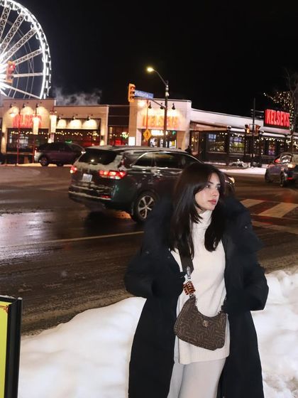 Capturing the vibrant nightlife of Clifton Hill in Niagara Falls. This photo, with the iconic SkyWheel in the background, is perfect for showcasing an outfit for a fun night out.