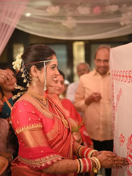 A side profile of the bride during a ritual, showing her elegant hairstyle with a traditional braid and flowers.