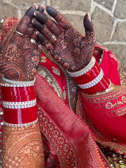 A classic bridal shot, with the deep red of the henna stain and the red of the chooda bangles. This is the picture-perfect bridal look.