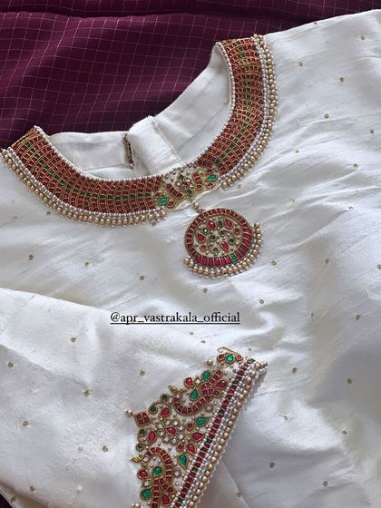 A matching off-white blouse with a necklace embroidery design.