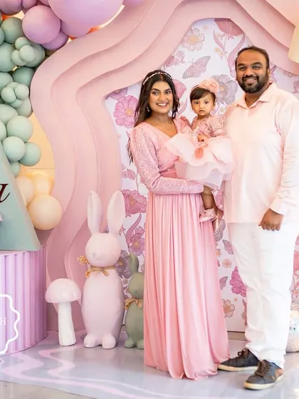 A beautiful family portrait in front of the custom "Onderland" backdrop, capturing a perfect moment from Aahana's first birthday celebration.