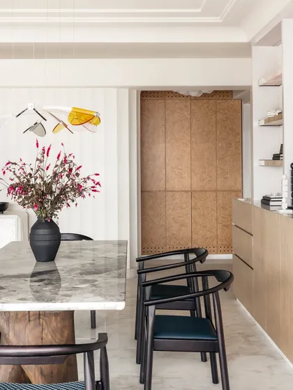 The dining room in Apartment O2 is infused with life. A beautiful floral arrangement complements the colorful acrylic leaves of the overhead light fixture, adding a touch of whimsy.
