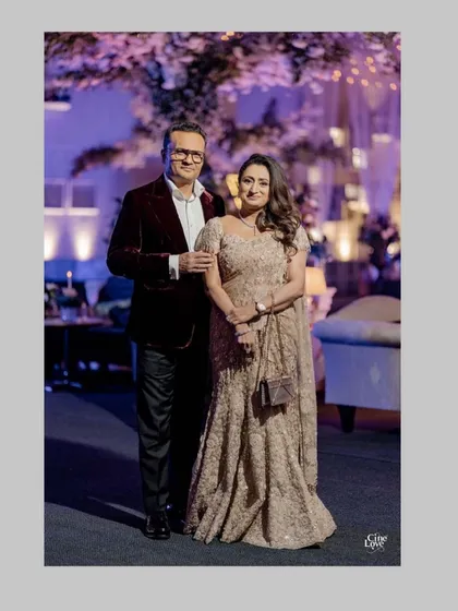 The parents of the groom, exuding elegance at the cocktail soirée. Her shimmering gold gown and his rich burgundy velvet jacket are perfectly coordinated, reflecting a timeless and sophisticated style. We ensure the parents feel just as special and celebrated as the couple.