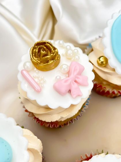 For a touch of elegance, this cupcake topper features a golden rose, delicate pearls, and a sweet pink bow. It's perfect for a sophisticated baby shower theme.