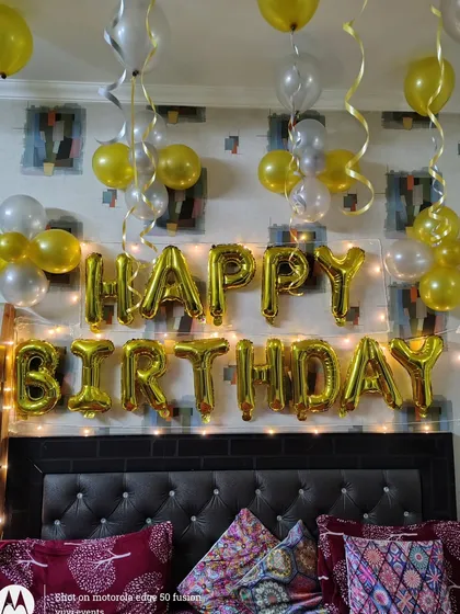 A close-up of the 'Happy Birthday' foil balloons with fairy lights. This simple addition can make any home decoration feel more special and festive.