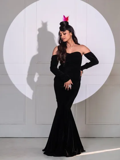Another take on the classic Hollywood spotlight portrait. This pose shows off the full silhouette of the black gown and the creative, hat-like hairstyle.