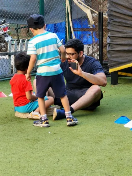 Sometimes the best part of coaching is learning from the kids. Here, I'm getting a lesson in "The Wheels on the Bus"! These moments of connection are what build trust and make learning feel like play.
