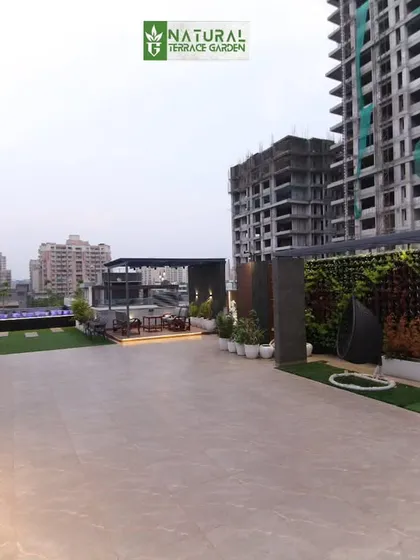 A large rooftop project in Sushant Lok, Gurgaon, with a city backdrop. The design incorporates vertical gardens, a pergola, and a large open tiled area.