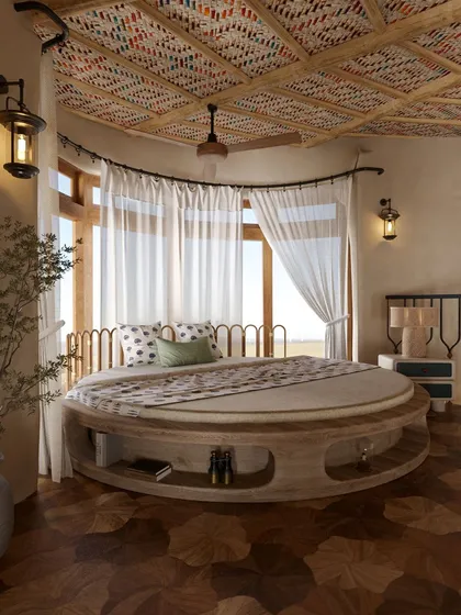 This view of the circular bed shows the vibrant, patterned textile used for the ceiling. This detail, combined with the wooden floors and natural light, creates a room that is both playful and deeply connected to an earthy aesthetic.