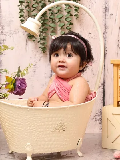 Bath time has never been this cute. This baby is all smiles in a miniature tub, surrounded by flowers and bubbles in a specially designed splash-and-play setup.