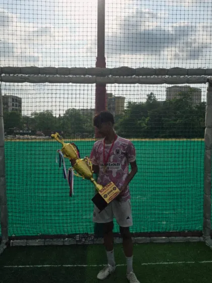 A solo moment with the prize. One of our players holds the hard-earned trophy after a successful tournament, a symbol of individual contribution to the team's success.