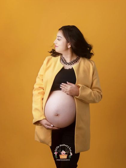 A pop of color can bring so much energy to a photo. This bright yellow backdrop and stylish jacket create a modern and confident maternity look.