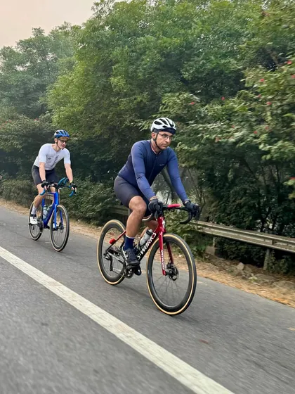 A paceline of three riders cruising down a tree-lined road on a Sunday morning.