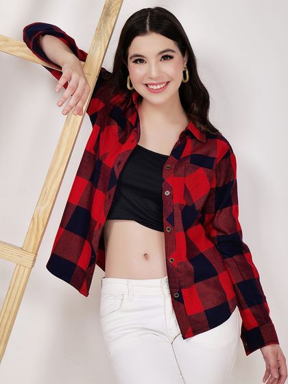 Using a simple prop like a ladder, we add a lifestyle element to this shot of a model in a red and blue plaid shirt.