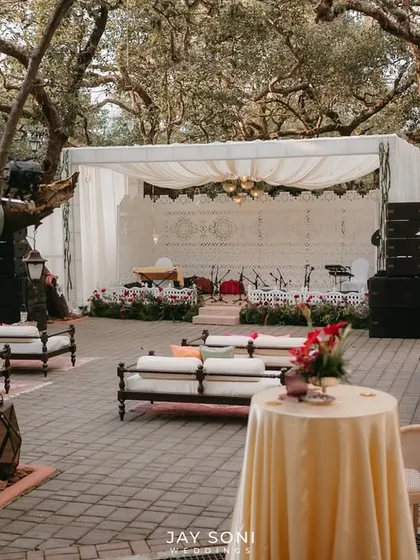 The stage and seating area for the Mehfil-e-Mehendi, showing how the traditional diwan-style seating and the elegant white stage create a perfect setting for a Qawali night.