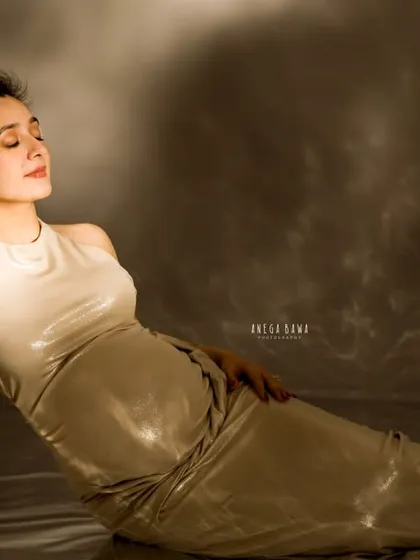 A serene, reclining pose against a dramatic, cloud-like backdrop. This artistic setup creates a dreamy and otherworldly feel for a truly unique maternity portrait.