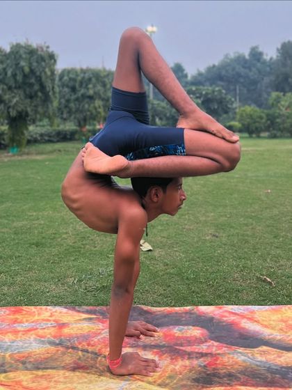 This handstand variation with legs in a modified lotus position requires a high degree of both strength and flexibility.