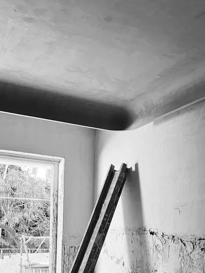 The finished curve where the wall meets the ceiling, a detail we pursued through numerous sketches and samples. The result is a subtle, sculptural element that defines the character of the space.
